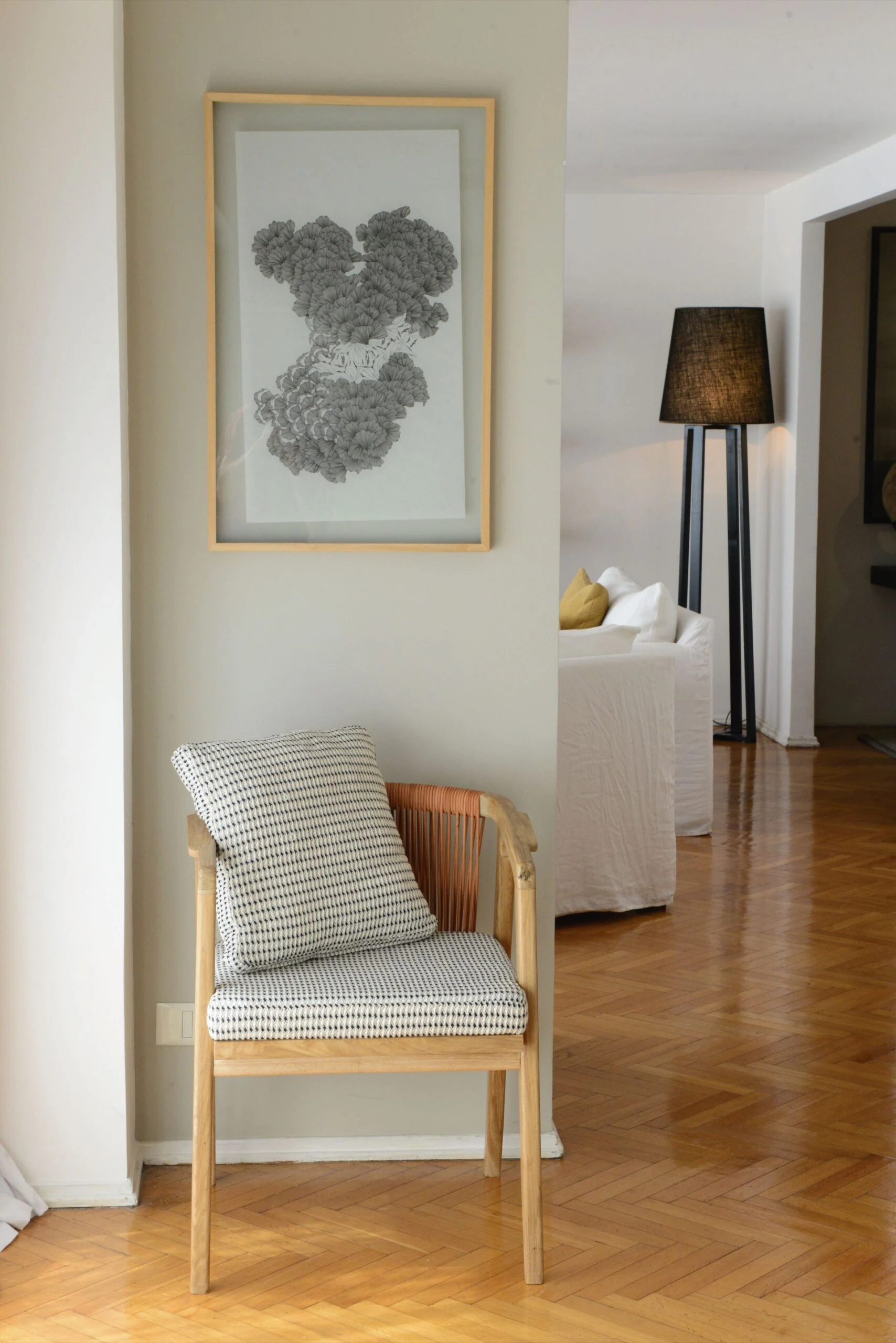 Un rincón de calma, con una silla con cordones de cuero (Somos Frontera) y un cuadro de Michelle Dabul.