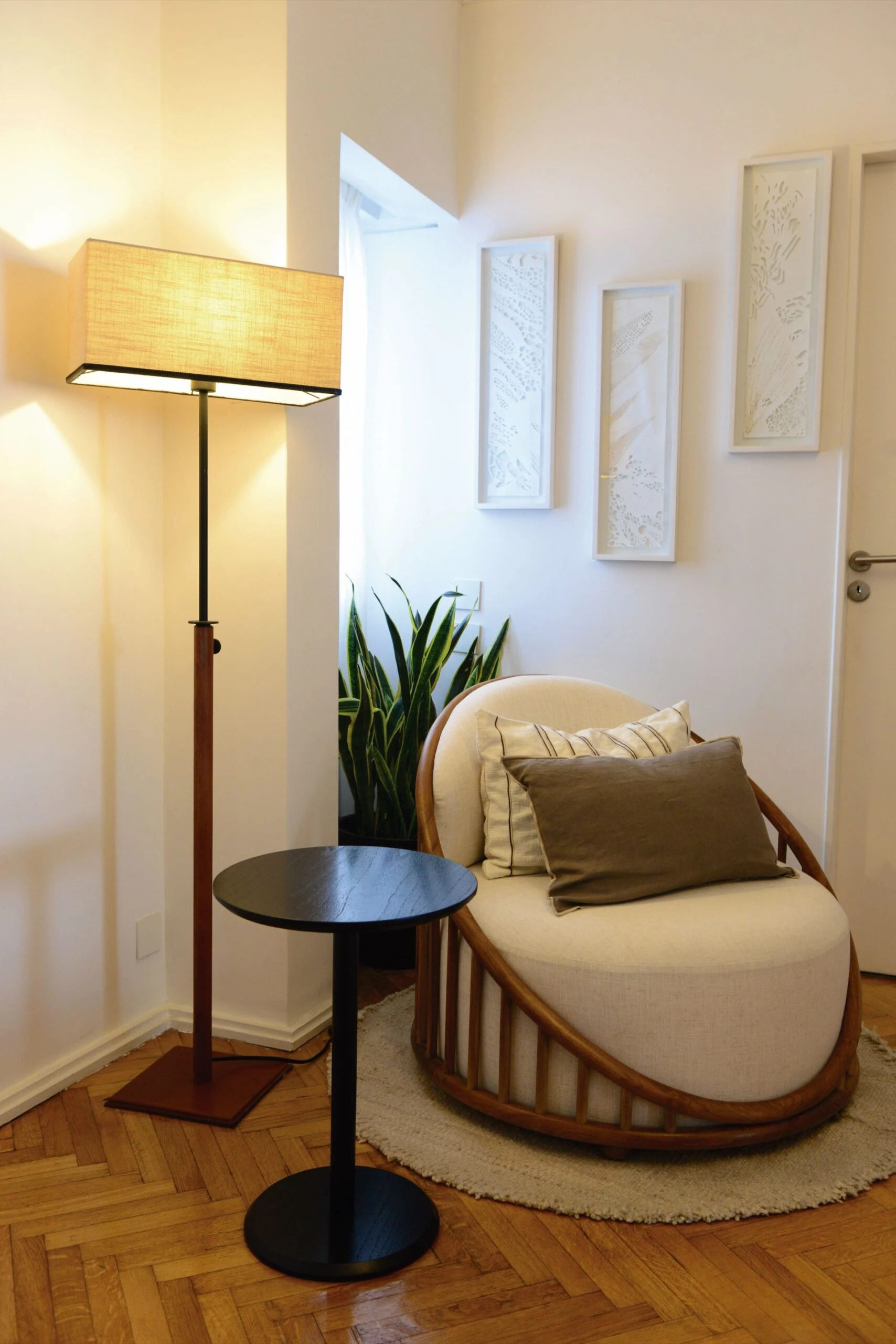 En un rincón del living, sillón individual de silueta curva, mesa auxiliar (Somos Frontera) y lámpara de pie (Eugenio Aguirre).