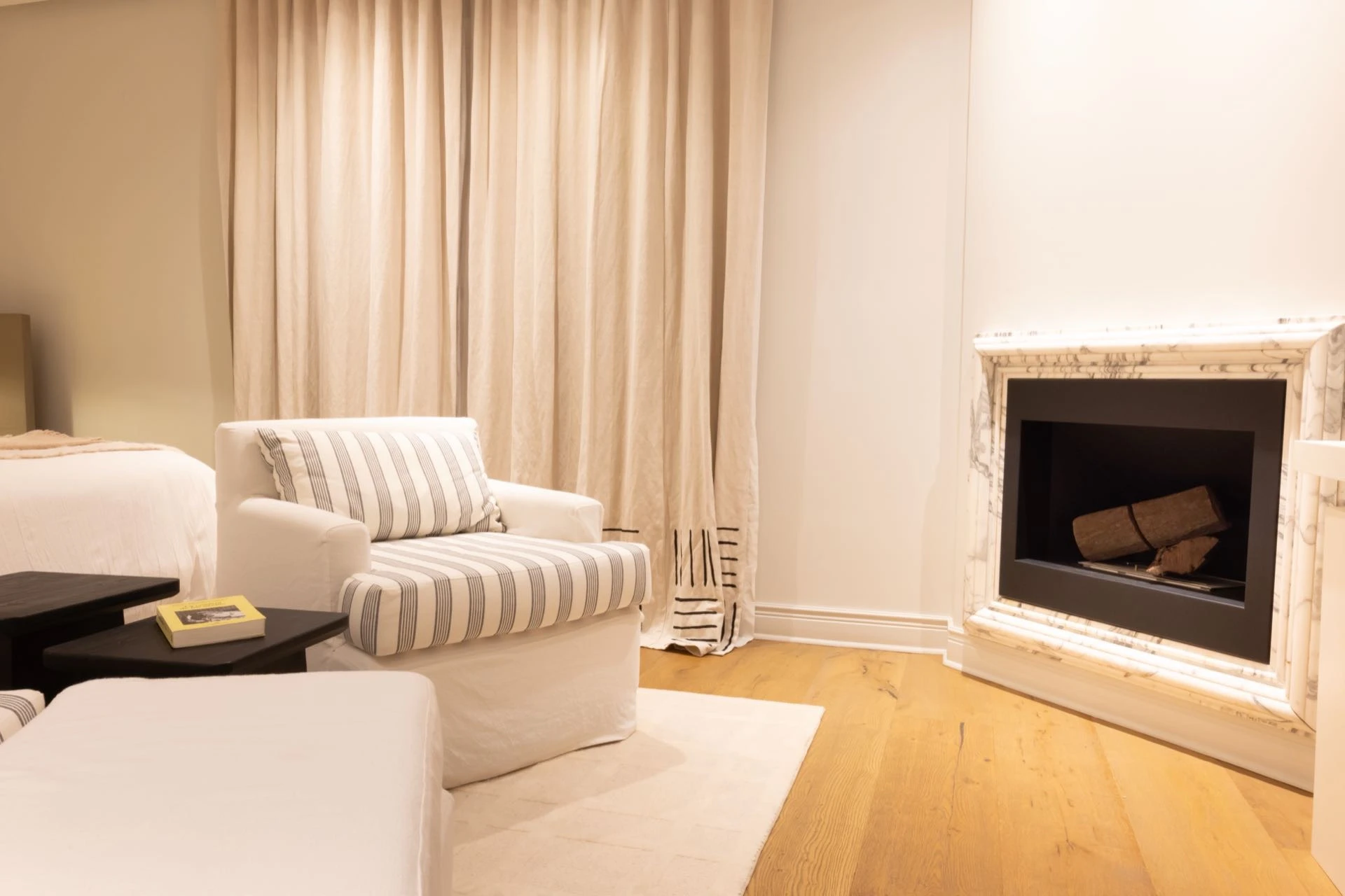 Frente a la cama, un pequeño living que se diseñó aprovechando la presencia de una chimenea original con marco de mármol.