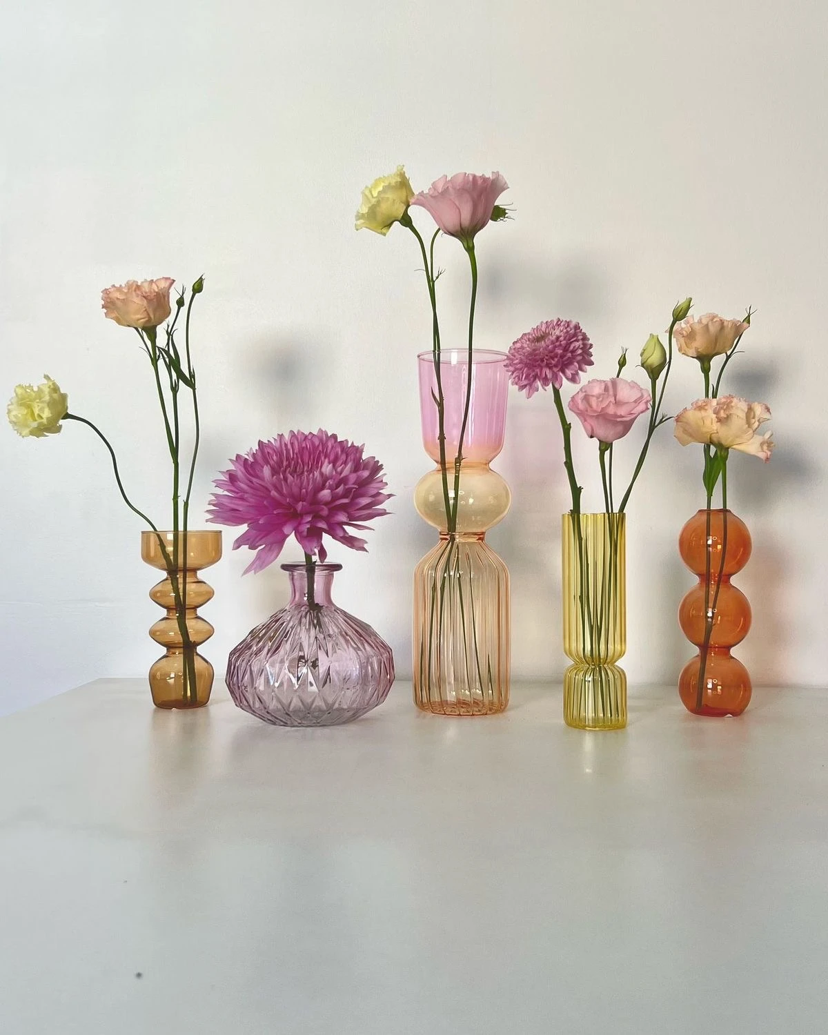 El secreto de usar muchos jarrones de cristal de colores está en la composición.  