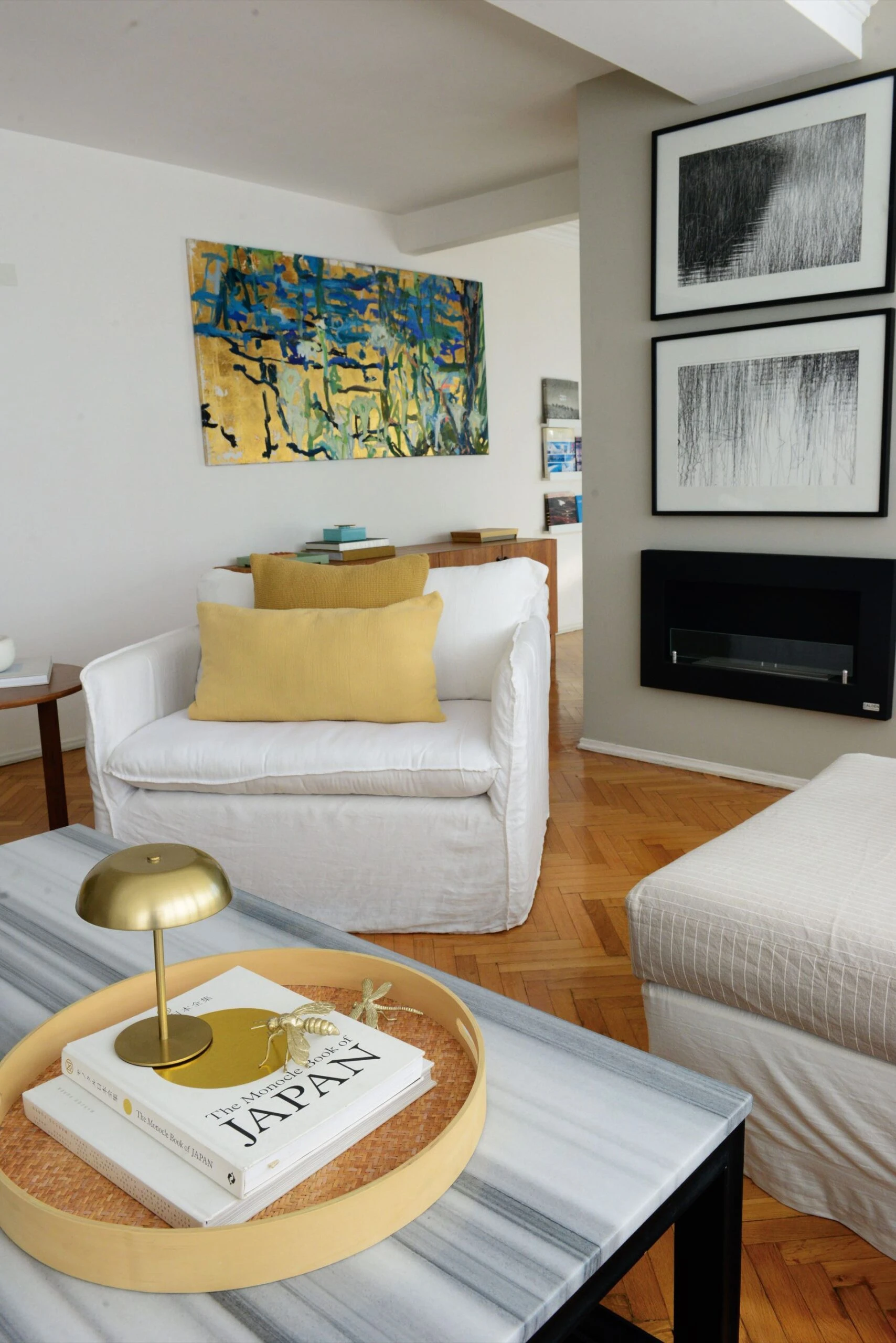 Otro rincón del living, con sillones con fundas blancas. Como fondo, fotografías de Daniel Ackerman.