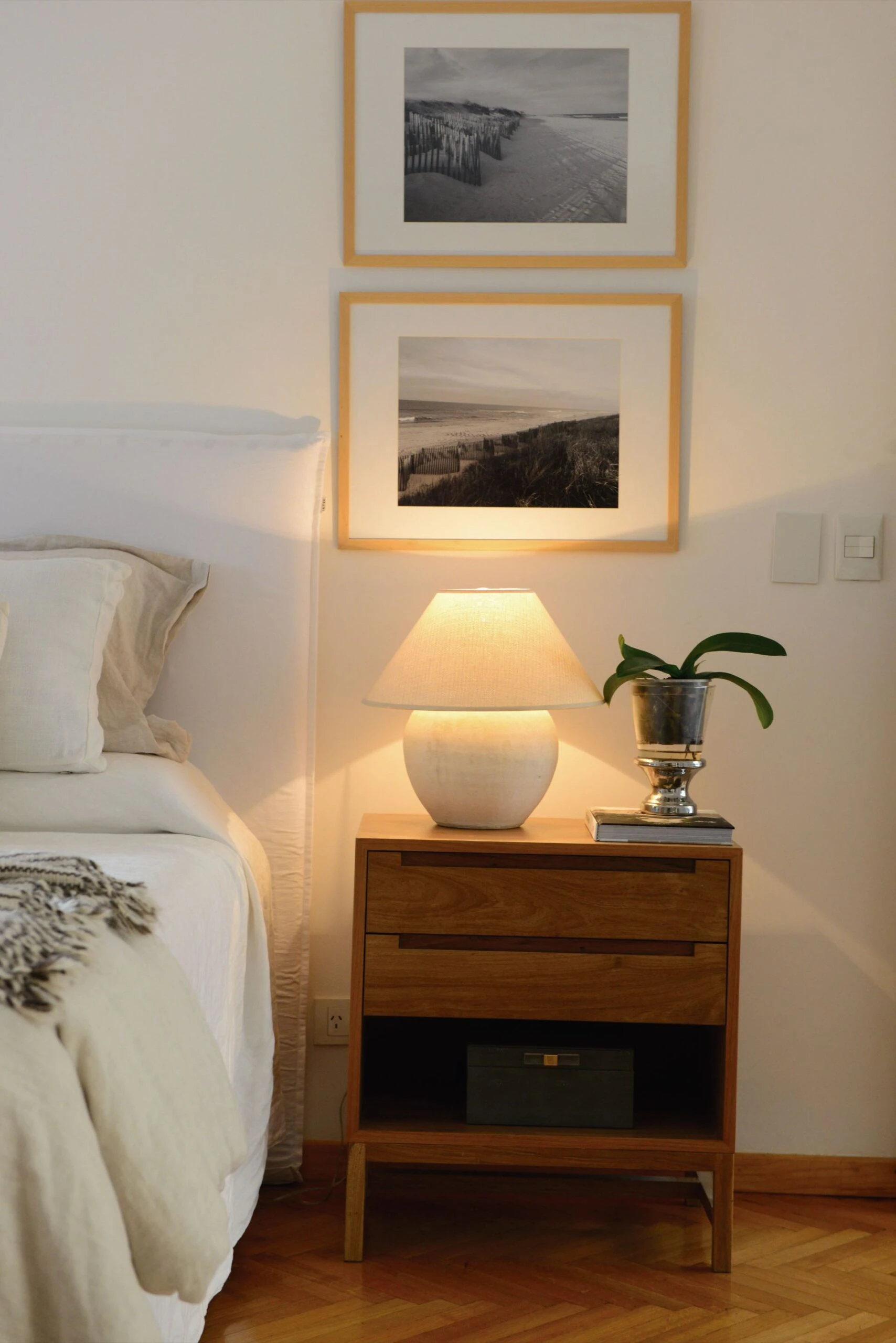 Junto a la cama, hay mesas de luz (Somos Frontera) con lámparas (Casa María Paula), más unas fotografías enmarcadas de la dueña de casa.