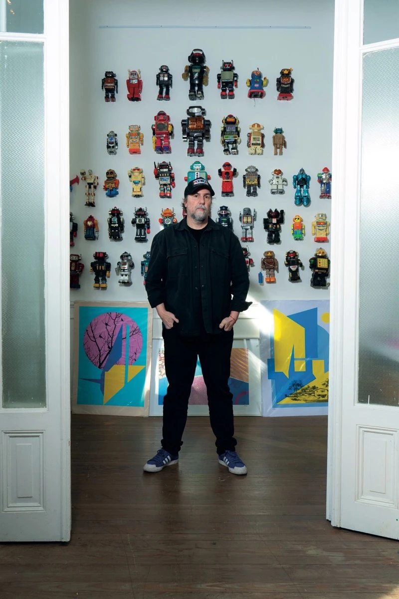  parado frente a decenas de robots en la pared,