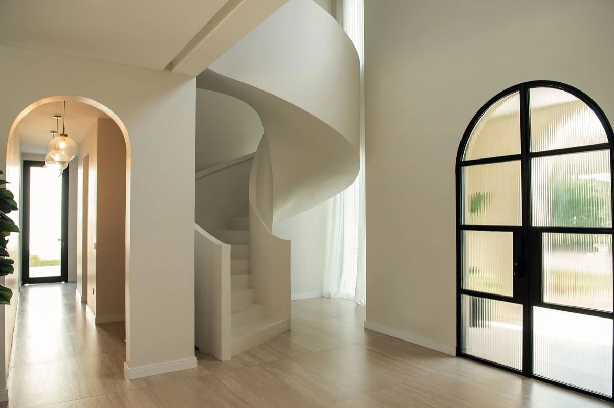 La puerta principal de hierro y vidrio con terminación de arco de medio punto