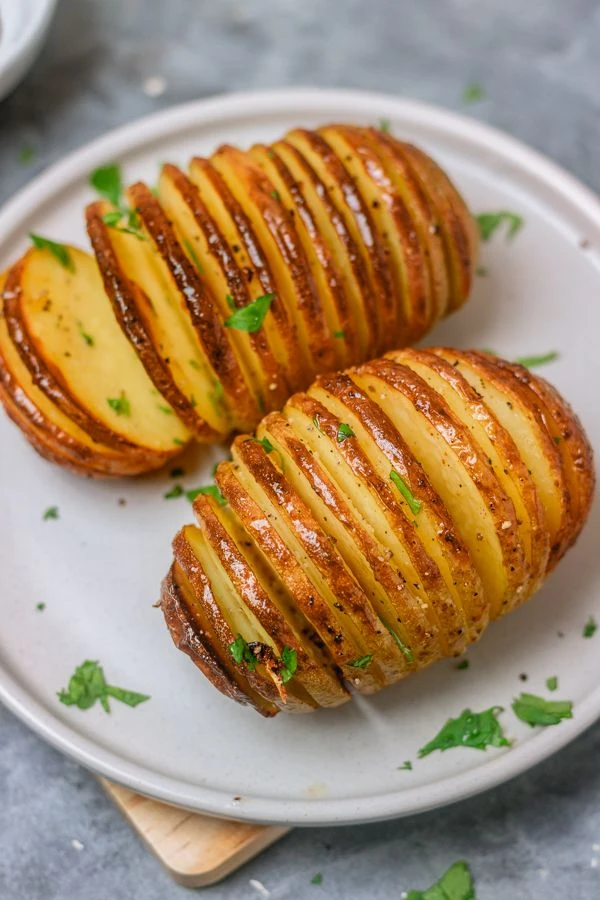 Papas hasselback: una receta con manteca de hierbas y parmesano

