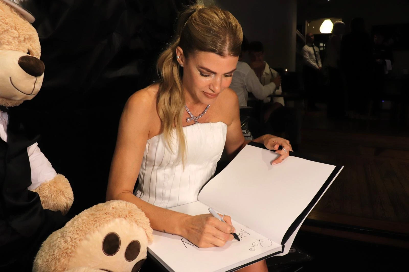 La modelo firmando los libros. 