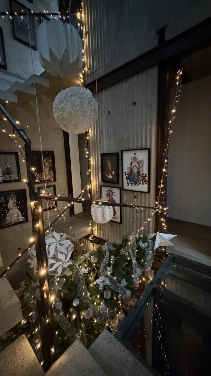 La tonalidad plateada se fusiona con las luces cálidas en el árbol de Navidad suspendido. 