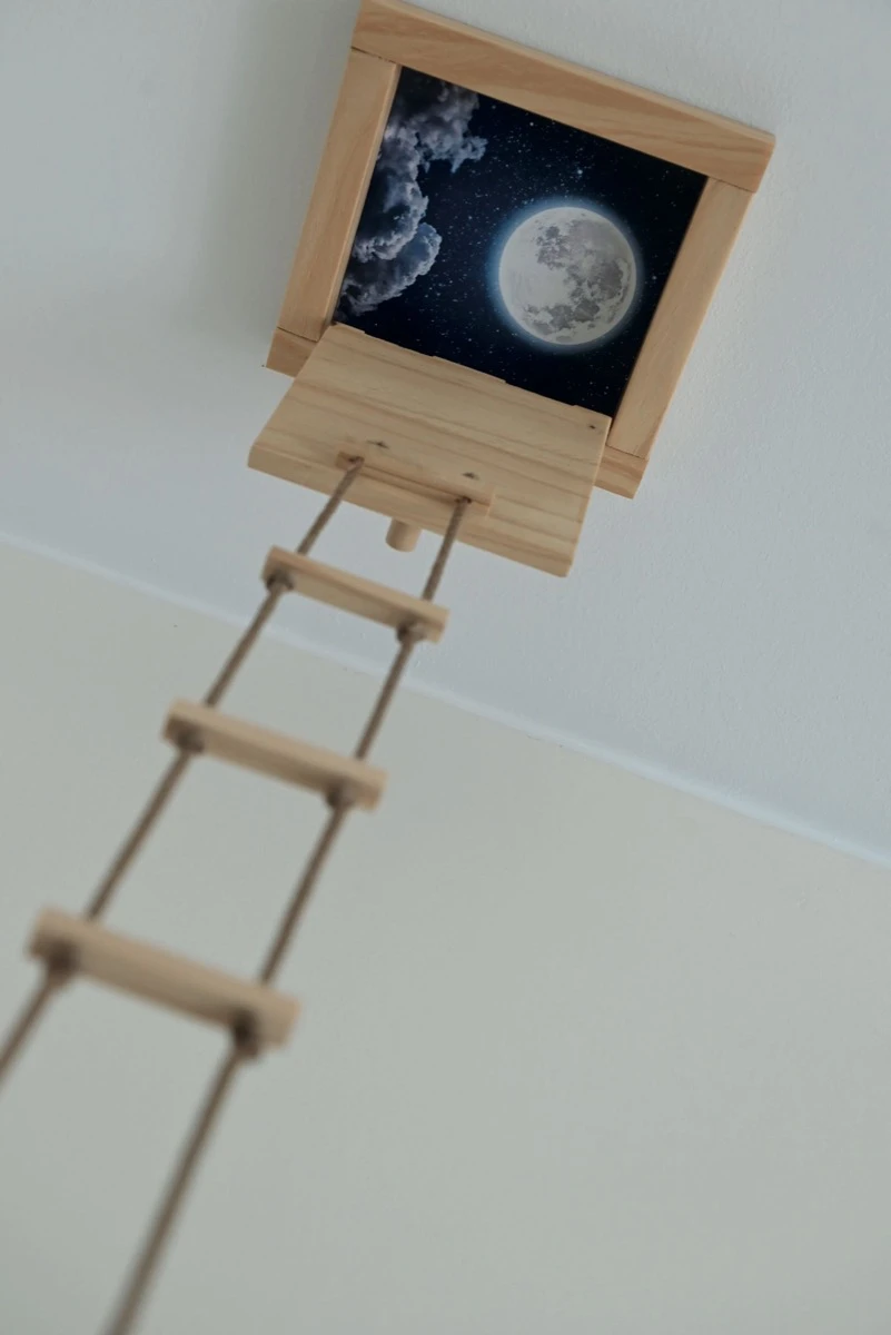 
Una escalera de acceso imaginario hacia el techo y ventana para ver la luna.  