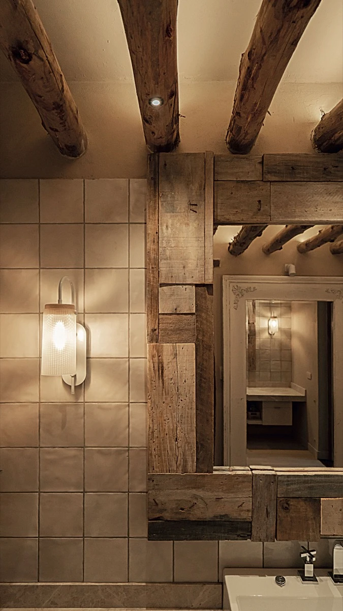 El techo del baño, atravesado por troncos con corteza de álamos.  