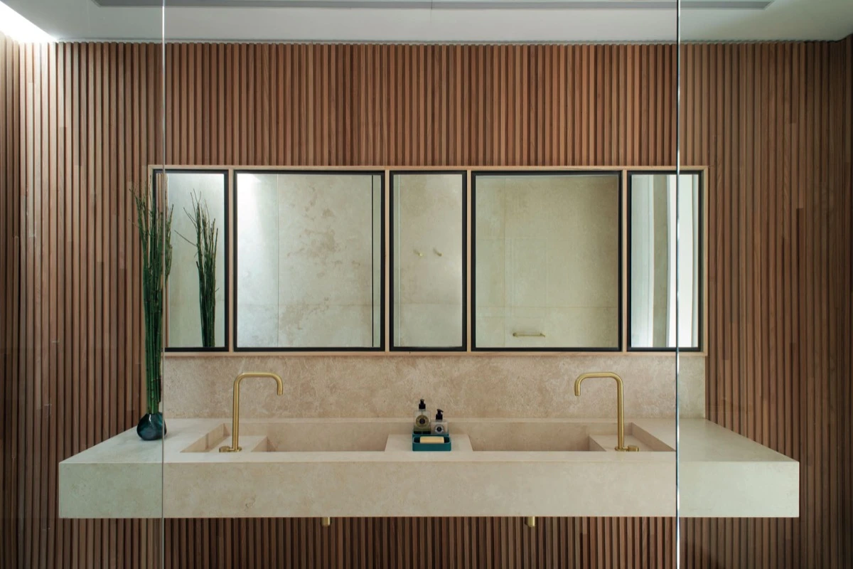 El travertino, único material que recorre todos los ambientes, se combinó con un revestimiento de madera Breeze Curitiba.  