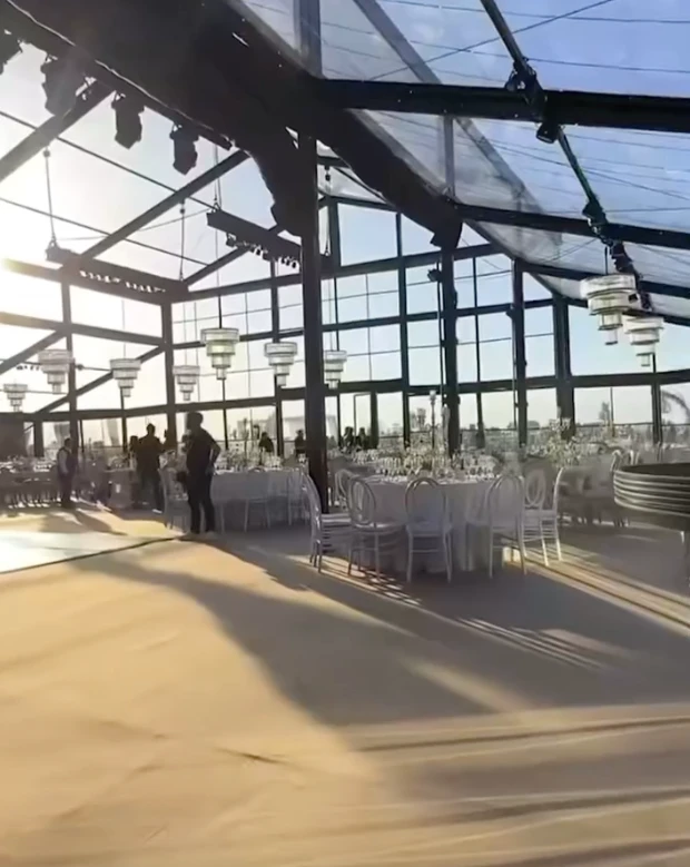 La escena inicial del video parece un fotograma de película: un campo infinito de girasoles abiertos en plena floración y un corredor natural entre las plantas, armado como pasillo de ceremonia. Sobre ese sendero amarillo y luminoso, la pareja camina hacia un altar sencillo, integrado al paisaje y pensado para que la naturaleza domine la imagen.

La luz del atardecer realza todo: el dorado del campo, el movimiento suave de las flores y la intimidad del momento. No hay estructuras pesadas ni elementos que compitan con el entorno. La apuesta es clara: dejar que la naturaleza sea el decorado.

Este tipo de ceremonias inmersivas, donde el escenario natural se convierte en parte del ritual, gana cada vez más terreno entre parejas que buscan autenticidad, emoción y simplicidad estética. El campo de girasoles aporta, además, un simbolismo potente: vitalidad, alegría y una idea muy poética de “buscar la luz”.

Una fiesta bajo techo vidriado: el jardín de invierno que dejó a todos sin palabras

Tras la ceremonia, el video muestra un segundo escenario igual de impactante: un jardín de invierno gigante, montado especialmente para la fiesta. Se trata de una estructura completamente vidriada, con paredes y techo transparentes que permiten ver el cielo nocturno desde adentro.

La iluminación cálida, a base de microleds y guirnaldas, crea un clima íntimo y elegante. Las mesas -tanto largas como redondas- están decoradas con flores blancas y verdes, velas y vajilla neutra. Todo pensado en clave natural, sin recargar, manteniendo la armonía con lo que ocurrió horas antes en el campo.

La gran virtud del espacio es que combina protección y aire libre: desde adentro se ve el cielo estrellado como si no hubiera techo, pero con la comodidad y el resguardo de un salón diseñado para una noche especial. El efecto es cinematográfico.

El cielo como protagonista y un cierre con fuegos artificiales

En los tramos finales del video, el techo vidriado funciona como pantalla: el cielo oscuro, las estrellas y el brillo del exterior se integran al ambiente. La fiesta transcurre literalmente “bajo las estrellas”, en un escenario que mezcla naturaleza y diseño sin perder calidez.

El cierre llega con fuegos artificiales en tonos dorados y blancos, ubicados a una distancia segura del salón. Reflejan su luz sobre los paneles del techo y generan un efecto envolvente, delicado y festivo. Es un final que potencia el clima emocional de toda la celebración.

Por qué estas bodas inspiran tanto

Las bodas como esta combinan tres elementos que conectan con una búsqueda contemporánea:

Rituales auténticos, donde los protagonistas se sienten parte del paisaje.

Experiencias sensoriales, donde la luz, el entorno y la atmósfera importan tanto como la decoración.

Naturaleza + diseño, en equilibrio, sin exageraciones y con intención clara.

La boda chaqueña ya circula por redes como ejemplo de una tendencia que crece: celebrar en escenarios que cuentan una historia, sin necesidad de grandes producciones, sino priorizando el entorno, la identidad de la pareja y la magia del momento.