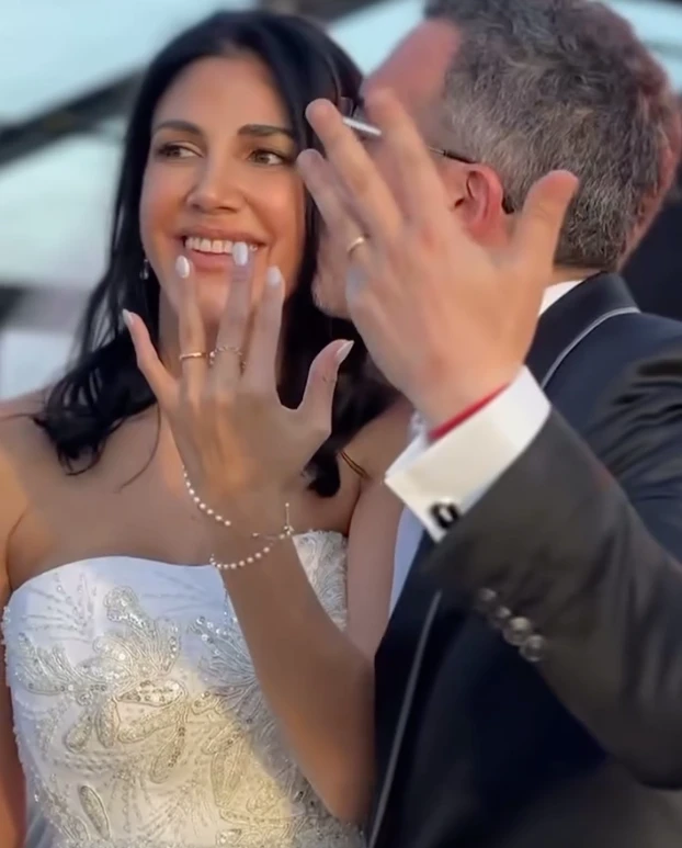 La escena inicial del video parece un fotograma de película: un campo infinito de girasoles abiertos en plena floración y un corredor natural entre las plantas, armado como pasillo de ceremonia. Sobre ese sendero amarillo y luminoso, la pareja camina hacia un altar sencillo, integrado al paisaje y pensado para que la naturaleza domine la imagen.

La luz del atardecer realza todo: el dorado del campo, el movimiento suave de las flores y la intimidad del momento. No hay estructuras pesadas ni elementos que compitan con el entorno. La apuesta es clara: dejar que la naturaleza sea el decorado.

Este tipo de ceremonias inmersivas, donde el escenario natural se convierte en parte del ritual, gana cada vez más terreno entre parejas que buscan autenticidad, emoción y simplicidad estética. El campo de girasoles aporta, además, un simbolismo potente: vitalidad, alegría y una idea muy poética de “buscar la luz”.

Una fiesta bajo techo vidriado: el jardín de invierno que dejó a todos sin palabras

Tras la ceremonia, el video muestra un segundo escenario igual de impactante: un jardín de invierno gigante, montado especialmente para la fiesta. Se trata de una estructura completamente vidriada, con paredes y techo transparentes que permiten ver el cielo nocturno desde adentro.

La iluminación cálida, a base de microleds y guirnaldas, crea un clima íntimo y elegante. Las mesas -tanto largas como redondas- están decoradas con flores blancas y verdes, velas y vajilla neutra. Todo pensado en clave natural, sin recargar, manteniendo la armonía con lo que ocurrió horas antes en el campo.

La gran virtud del espacio es que combina protección y aire libre: desde adentro se ve el cielo estrellado como si no hubiera techo, pero con la comodidad y el resguardo de un salón diseñado para una noche especial. El efecto es cinematográfico.

El cielo como protagonista y un cierre con fuegos artificiales

En los tramos finales del video, el techo vidriado funciona como pantalla: el cielo oscuro, las estrellas y el brillo del exterior se integran al ambiente. La fiesta transcurre literalmente “bajo las estrellas”, en un escenario que mezcla naturaleza y diseño sin perder calidez.

El cierre llega con fuegos artificiales en tonos dorados y blancos, ubicados a una distancia segura del salón. Reflejan su luz sobre los paneles del techo y generan un efecto envolvente, delicado y festivo. Es un final que potencia el clima emocional de toda la celebración.

Por qué estas bodas inspiran tanto

Las bodas como esta combinan tres elementos que conectan con una búsqueda contemporánea:

Rituales auténticos, donde los protagonistas se sienten parte del paisaje.

Experiencias sensoriales, donde la luz, el entorno y la atmósfera importan tanto como la decoración.

Naturaleza + diseño, en equilibrio, sin exageraciones y con intención clara.

La boda chaqueña ya circula por redes como ejemplo de una tendencia que crece: celebrar en escenarios que cuentan una historia, sin necesidad de grandes producciones, sino priorizando el entorno, la identidad de la pareja y la magia del momento.