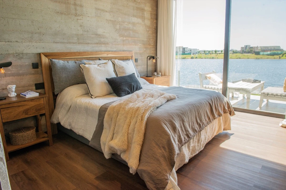 El dormitorio principal con vista al lago y salida a una terraza.