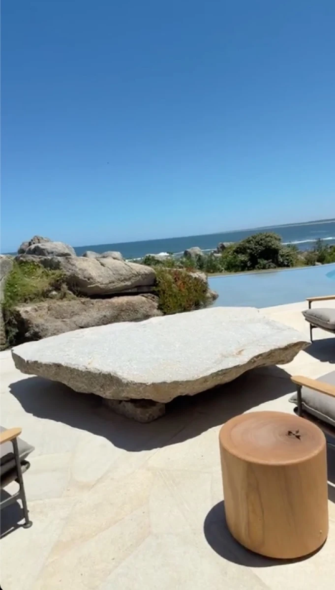 La mesa baja junto a la pileta, hecha con una inmensa roca natural del terreno.