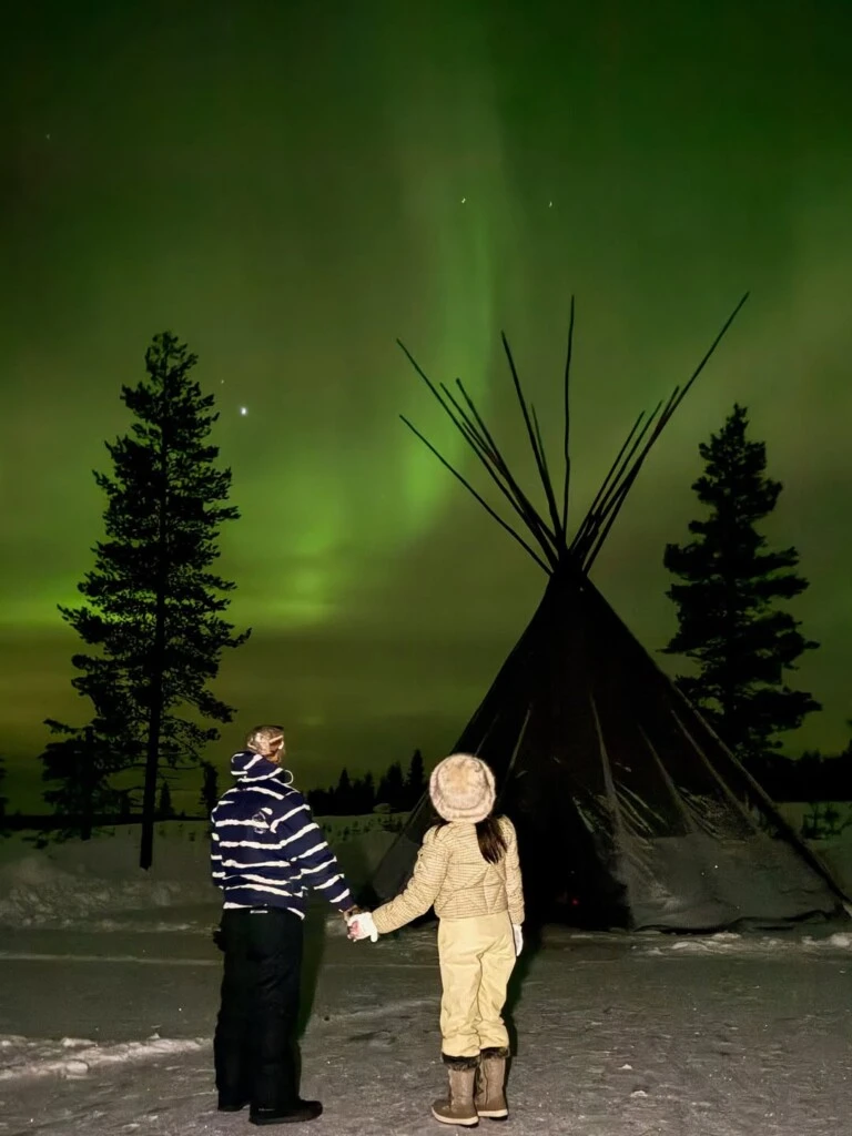 La pareja disfruta de una caminata entre árboles cubiertos de nieve en pleno invierno finlandés.