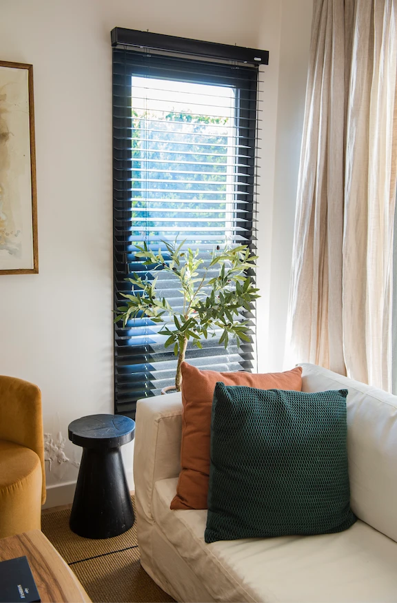 La luz natural que se filtra por el gran ventanal y las dos aberturas verticales con cortinas Woodblind, tamiza la escena.