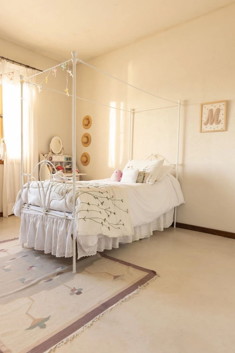 Romántico, un cuarto con cama con estructura de hierro blanco y baldaquino. 