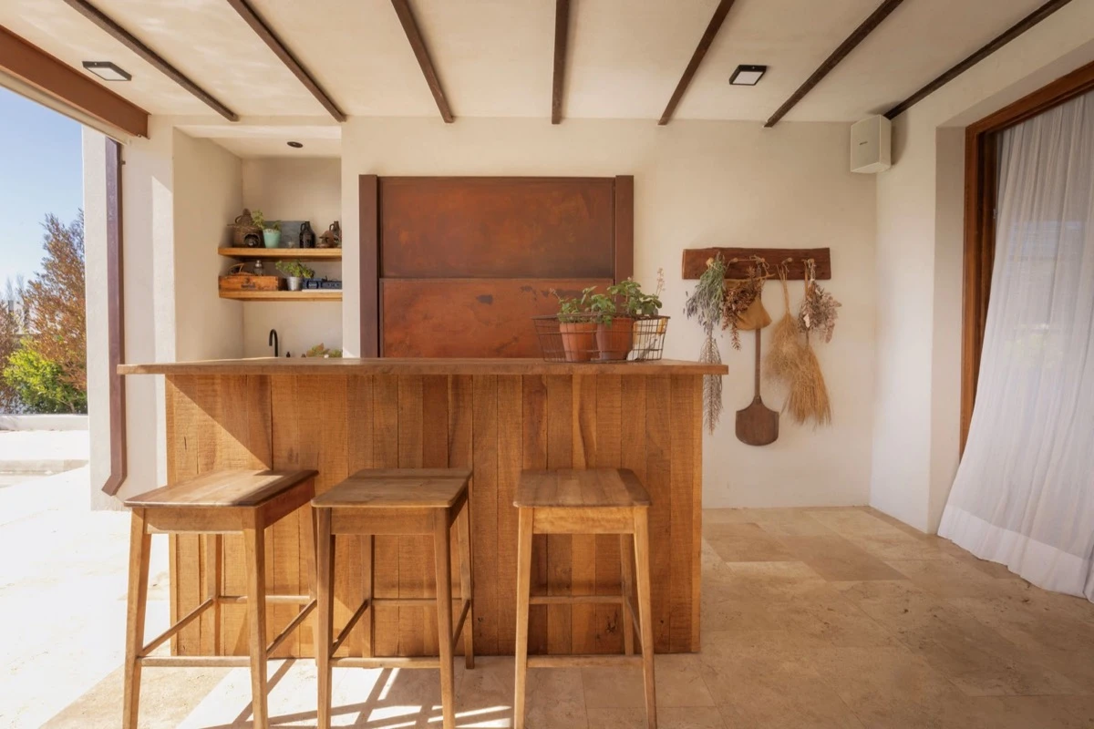 frente a la parrilla, una barra de apoyo en madera y hierro refuerza la idea de un espacio