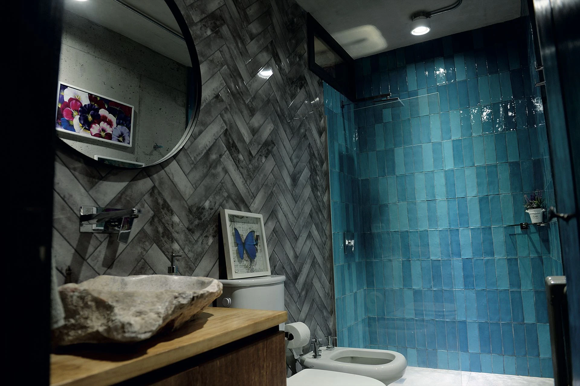 En el baño del cine, azulejos azules y un bloque de piedra como bacha. 