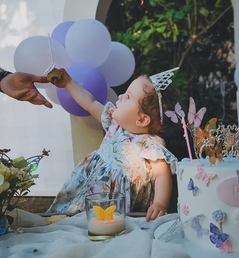La niña lució un vestido estampado floral con una corona de princesa.