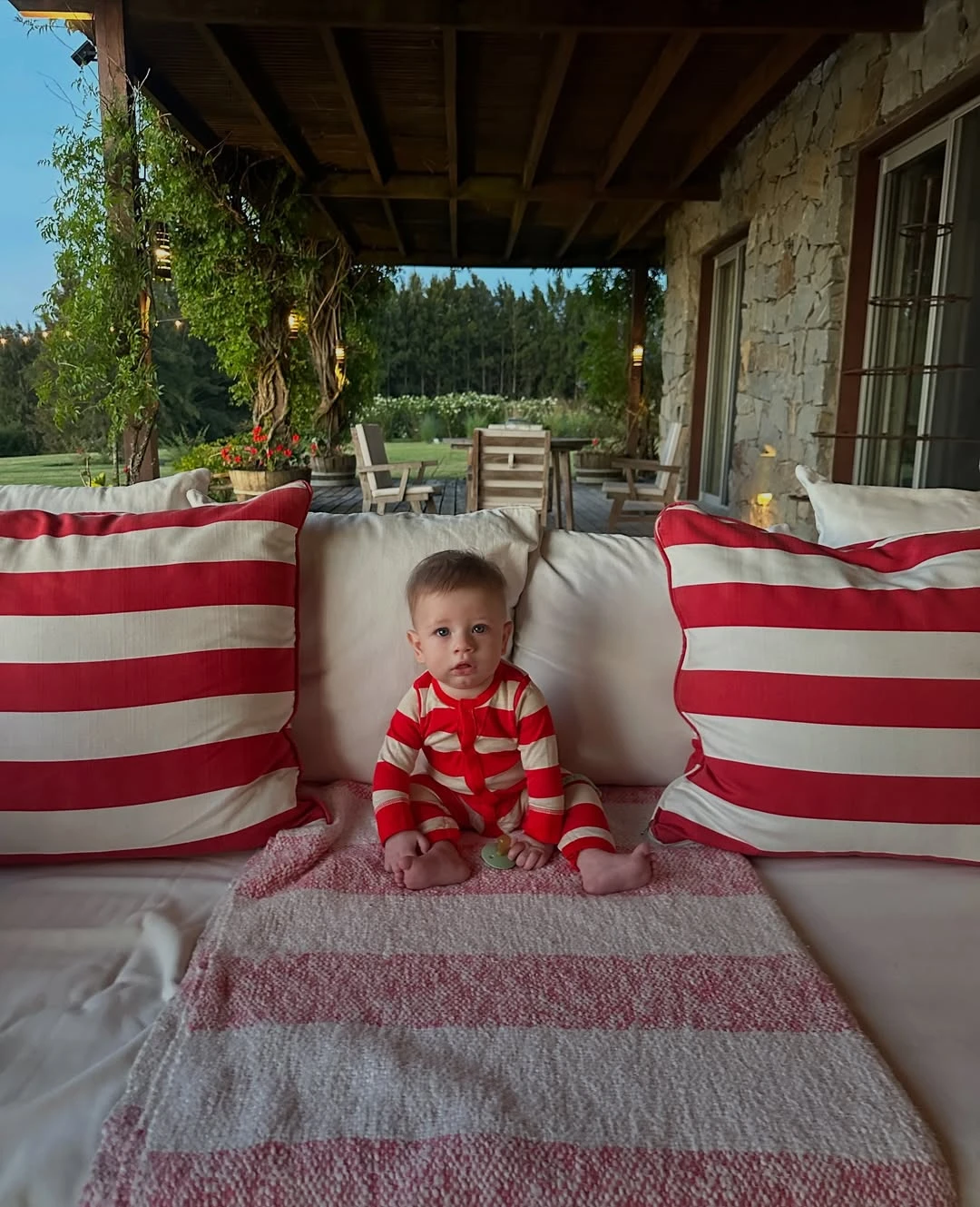 Bernardo, su sobrino nieto, junto a un mobiliario de madera y sillones con almohadones. Fotos: IG.