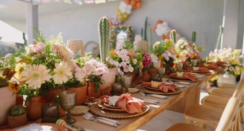 Mesas y sillas de madera, cactus, flores en tonos tierra y colores vibrantes, además de banderines colgados formaron parte de la gran decoración del cumpleaños.