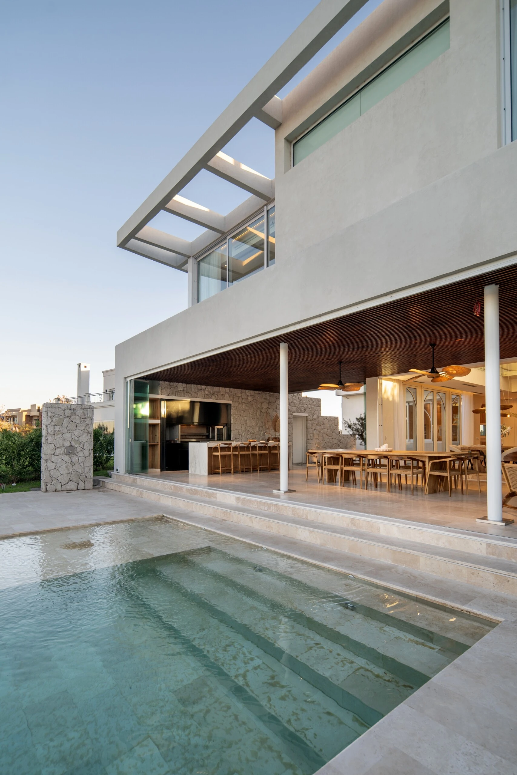 El espacio en el que la casa se conecta con jardín, la pileta y la laguna más alla.