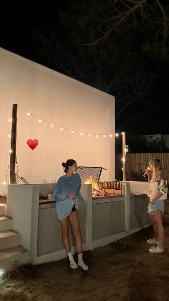 Zaira junto a una amiga al lado de la parrilla a la espera del gran banquete.