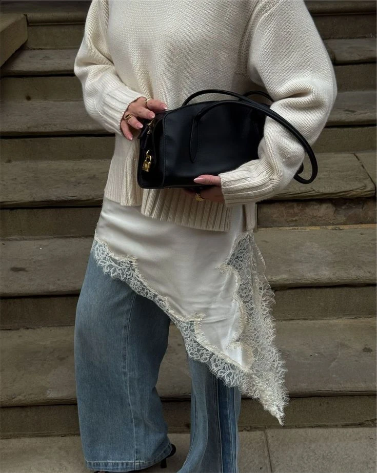 El tejido del sweater, asociado al confort y al abrigo, se combina con la sutileza del encaje, generando una tensión visual sofisticada y actual.