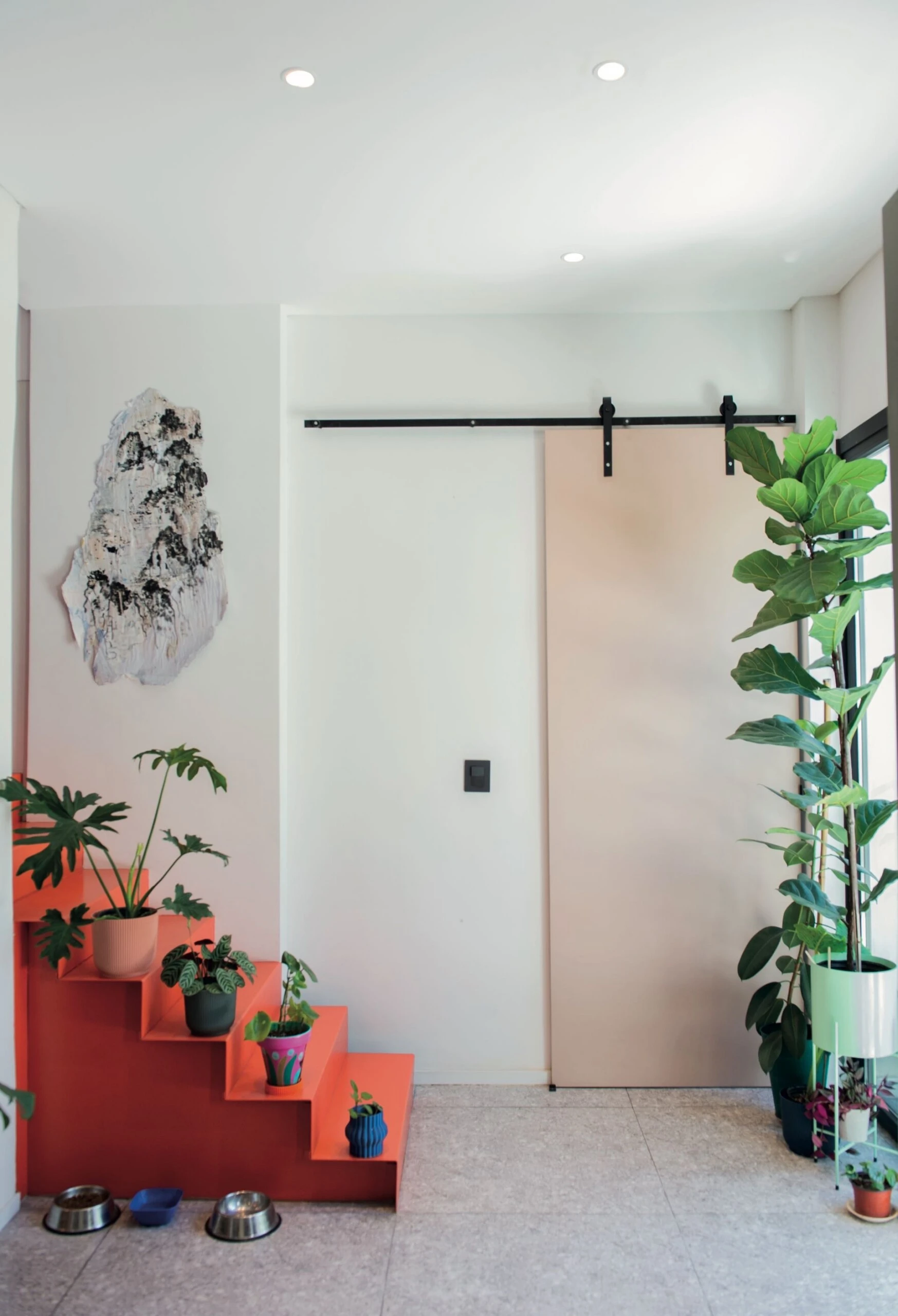 Tratada casi como una instalación artística, este volumen escultórico pintado en un tono naranja/ladrillo 