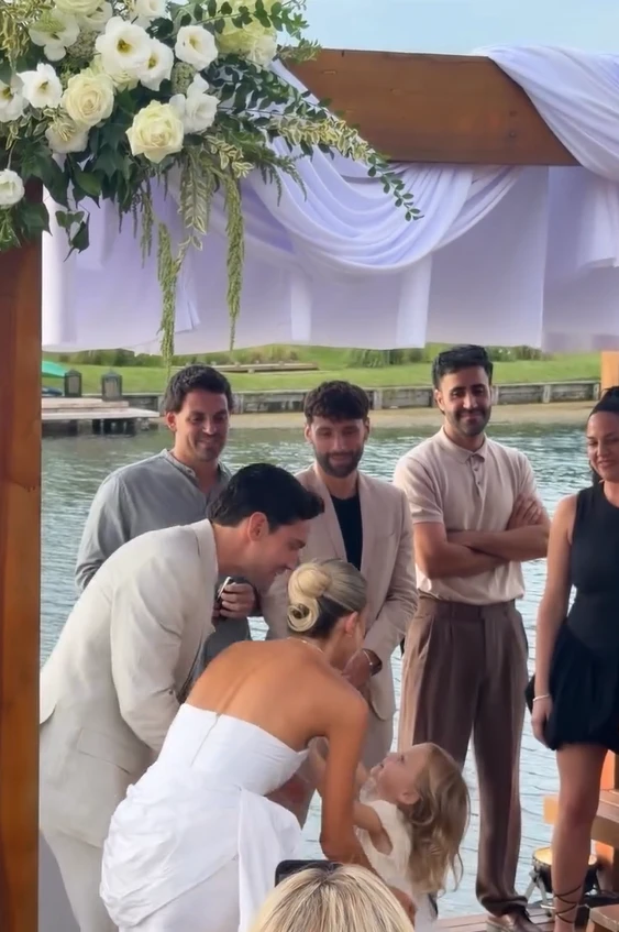 Vita, la hija de la pareja, se acercó antes de que llegaran al arco floral y caminó junto a ellos. 