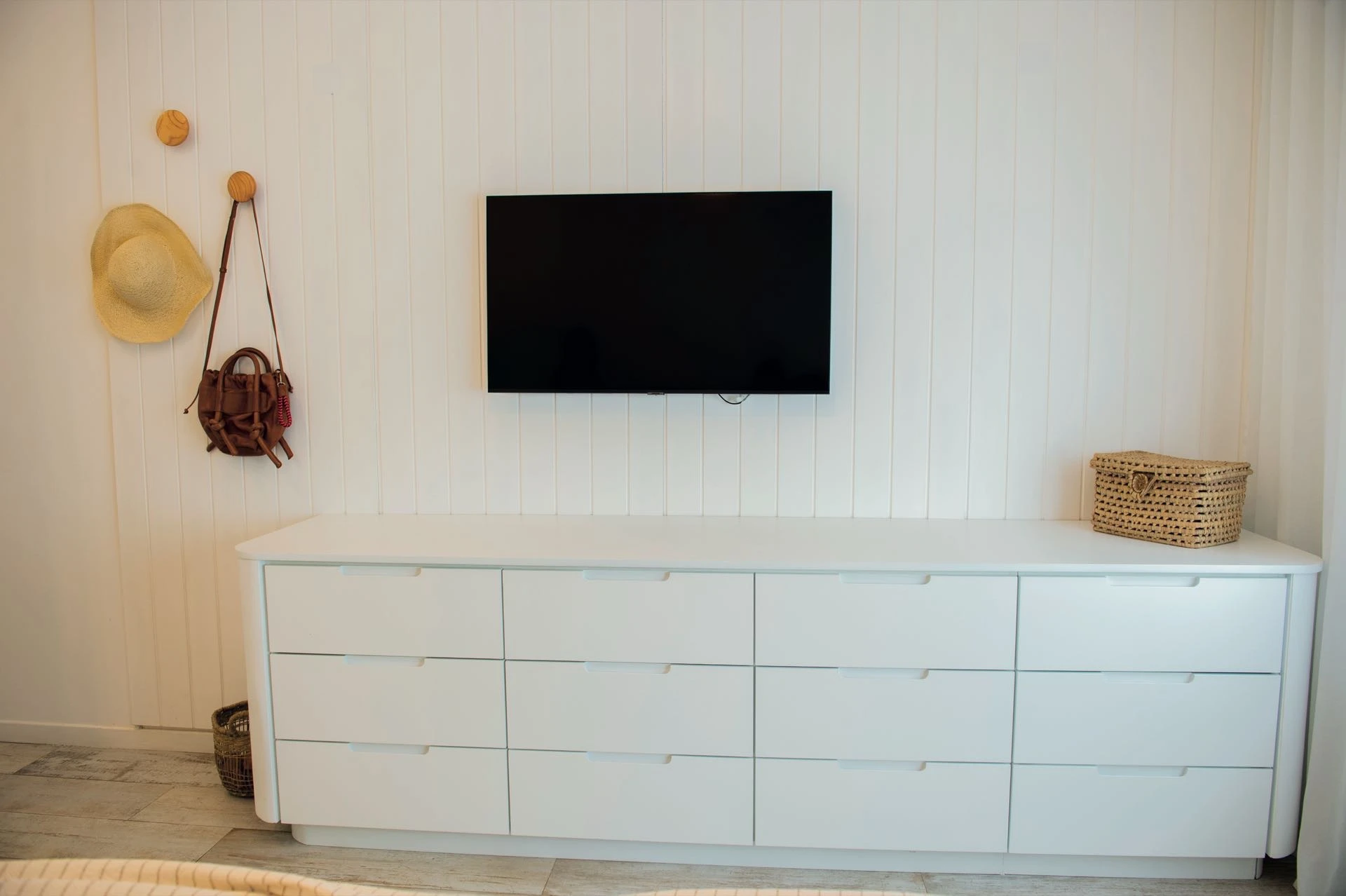 un mueble laqueado blanco con cajones organiza el guardado y mantiene la estética limpia del ambiente