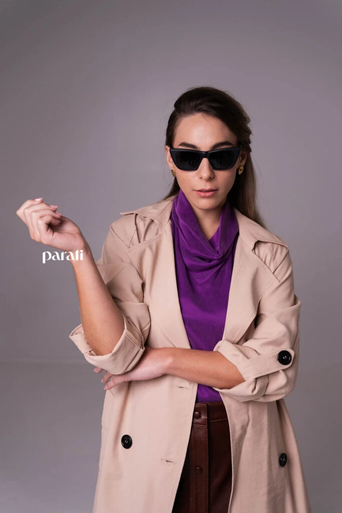 Trench de gabardina liviana color beige @concepcion.b.a; top musculosa de cupro y viscosa, con cuello alto @claraibargurenoficial; falda de cuero marrón con botones delanteros @mv.leather.studio; zapatos marrones taco fino, bajo @mishkabuenosaires; aros dorados @tina.allo; anteojos cat eyes marco negro @absurda_optica