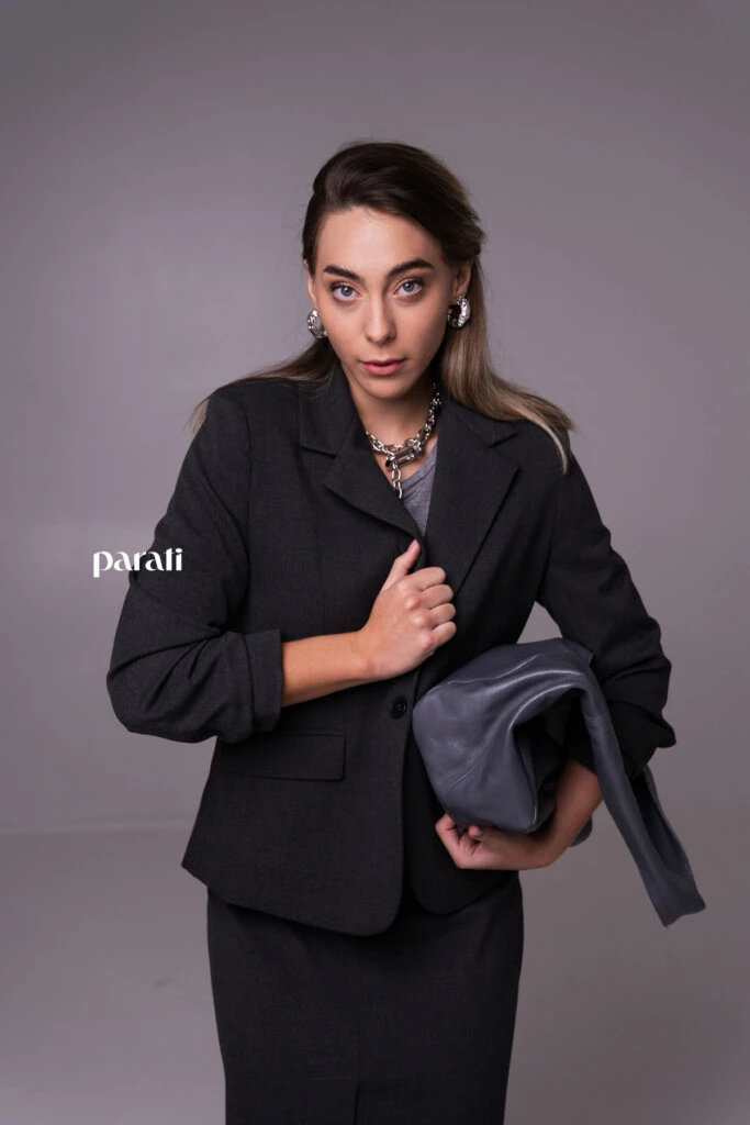 Conjunto sastrero de blazer y falda recta con tajo delantero, y remera cuello redondo mangas 3/4 @verapasionadas; zapatos de charol gris @pruneoficial; bolso de charol gris @mishkabuenosaires; aros argolla gruesa y collares de cadena plateados @tina.allo; anteojos de sol negros @bplusd.a