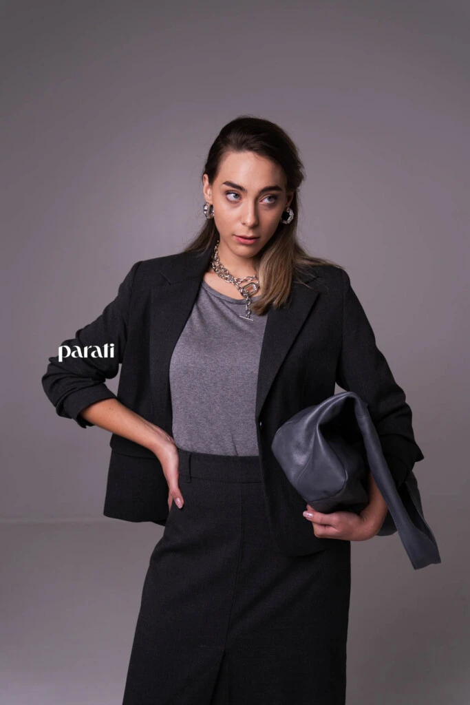 Conjunto sastrero de blazer y falda recta con tajo delantero, y remera cuello redondo mangas 3/4 @verapasionadas; zapatos de charol gris @pruneoficial; bolso de charol gris @mishkabuenosaires; aros argolla gruesa y collares de cadena plateados @tina.allo; anteojos de sol negros @bplusd.a