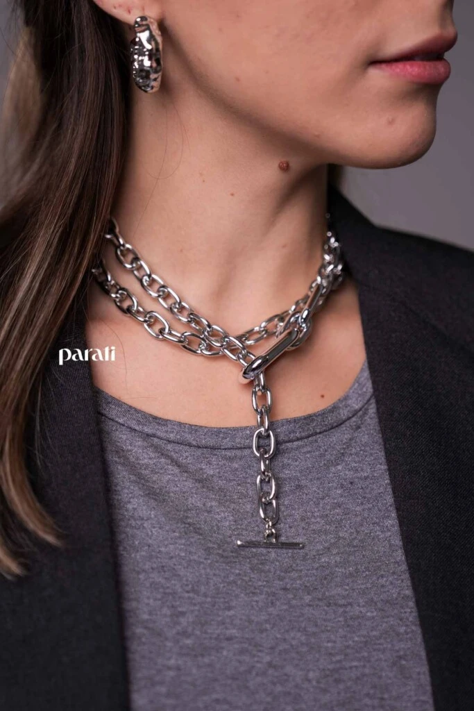 Conjunto sastrero de blazer y falda recta con tajo delantero, y remera cuello redondo mangas 3/4 @verapasionadas; zapatos de charol gris @pruneoficial; bolso de charol gris @mishkabuenosaires; aros argolla gruesa y collares de cadena plateados @tina.allo; anteojos de sol negros @bplusd.a