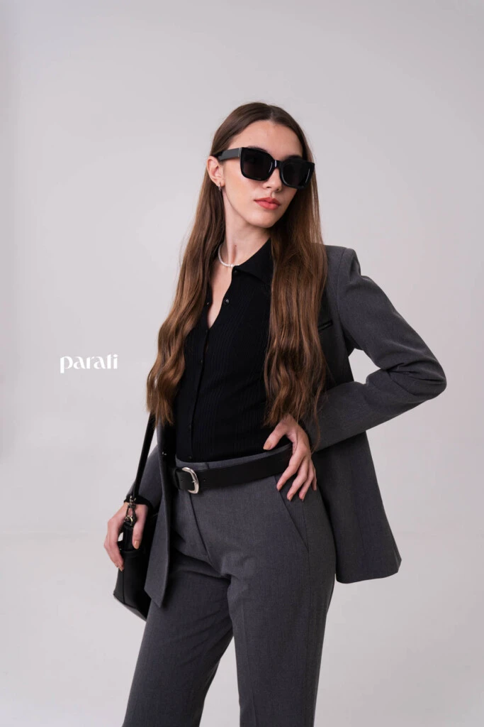 Traje sastrero de viscosa gris @markovaoficial; cárdigan negro cuello polo y cartera de cuero negra @pruneoficial; collar de perlas y argollas de plata @gingerjoyeria; anteojos de sol marco negro @bplusd.ar; botineta y cinturón de cuero negro @oggizapatos