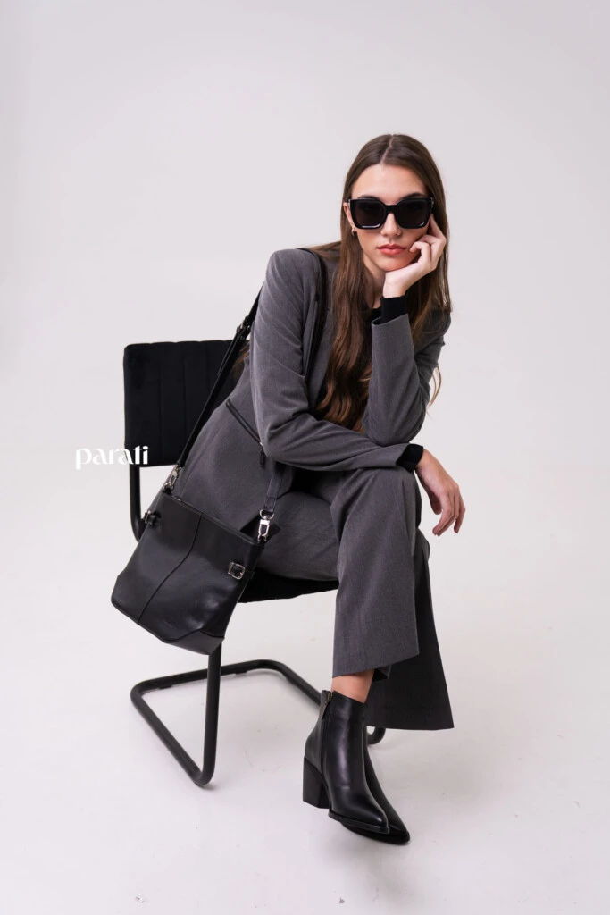 Traje sastrero de viscosa gris @markovaoficial; cárdigan negro cuello polo y cartera de cuero negra @pruneoficial; collar de perlas y argollas de plata @gingerjoyeria; anteojos de sol marco negro @bplusd.ar; botineta y cinturón de cuero negro @oggizapatos