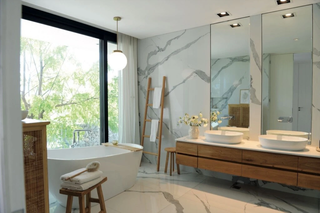 En el baño, superficies de gran formato, madera natural y líneas limpias. 