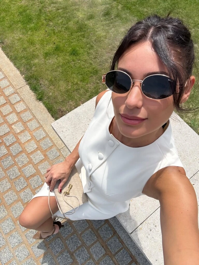 Pampita apostó por un vestido blanco sin mangas con botones protagonistas en la parte frontal y cinturón, una propuesta clásica y elegante que acompañó con stilettos color camel, cartera beige y anteojos de sol de formato ovalado.