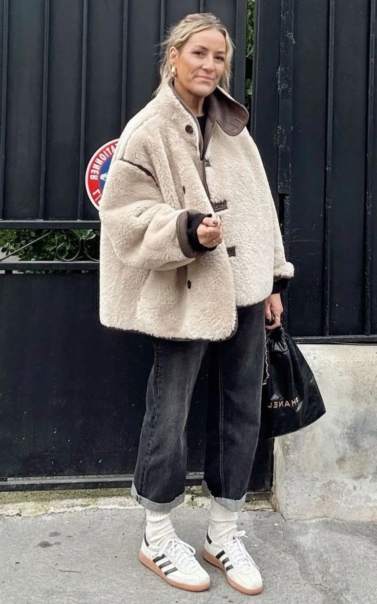 6. Accesorios XXL: la bufanda como abrigo
A veces, un accesorio tiene el poder de definir todo un conjunto. En "Street Style 2025 Winter (1).jpeg", vemos cómo una bufanda XXL en tono neutro se vuelve el eje del look, envolviendo un abrigo de textura suave en color chocolate. Los pantalones de corte relajado y las botas de cordones en tono suela refuerzan esa estética artesanal y abrigada que tanto buscamos cuando baja la temperatura.