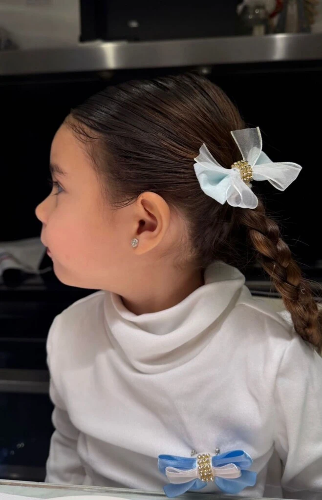 Sarah llevó el pelo peinado con raya al medio y dos trenzas bien tirantes, un estilo clásico que acompañó a la perfección la inspiración tradicional del outfit.