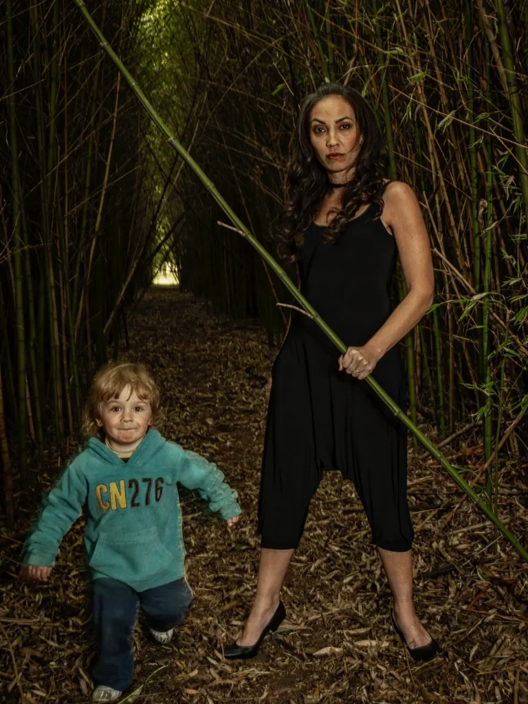 En la fotografía, tomada años atrás, madre e hijo aparecen en un entorno natural, rodeados de cañas. Ernestina mira a cámara con una expresión seria e intensa, mientras Benicio, todavía pequeño, observa el lente con curiosidad.