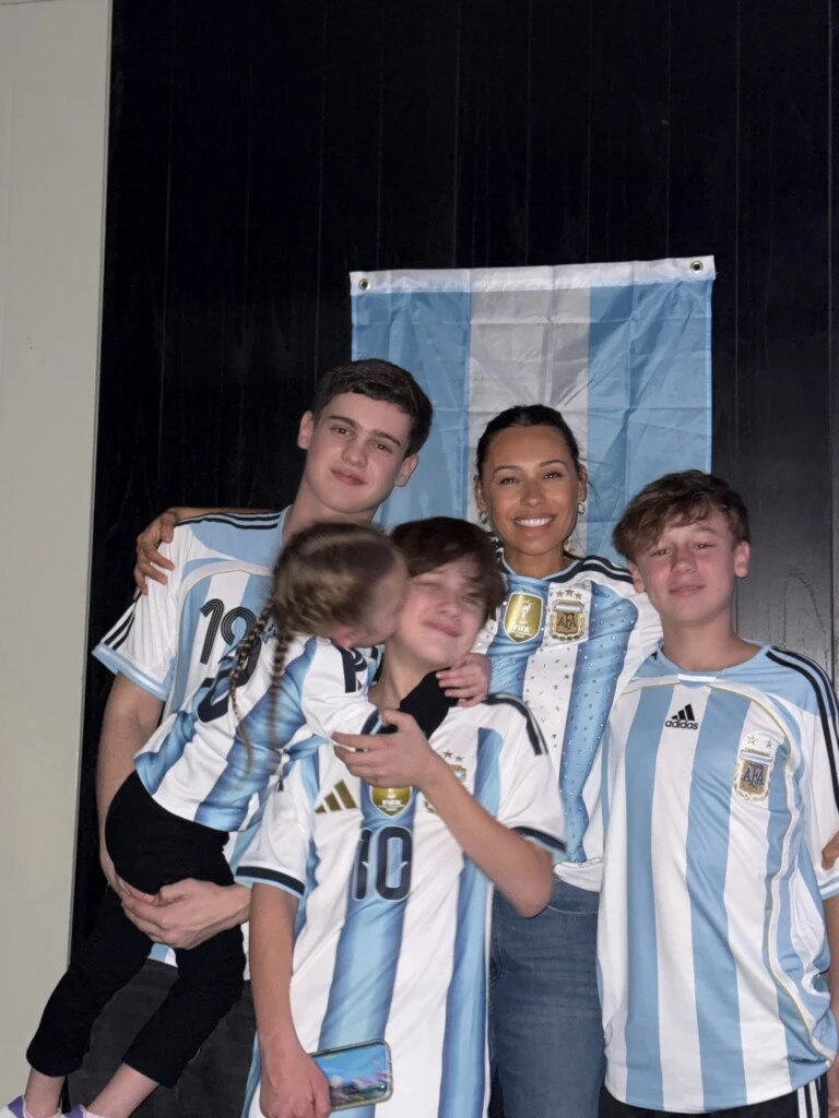 Toda la familia se fotografió detrás de una bandera argentina y frente a la pantalla donde siguieron el partido, celebrando el triunfo con una enorme sonrisa.