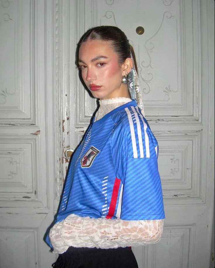  Esta mezcla de códigos opuestos, que une la estética futbolera con detalles románticos y femeninos, se convirtió en una de las favoritas de influencers y referentes de moda.