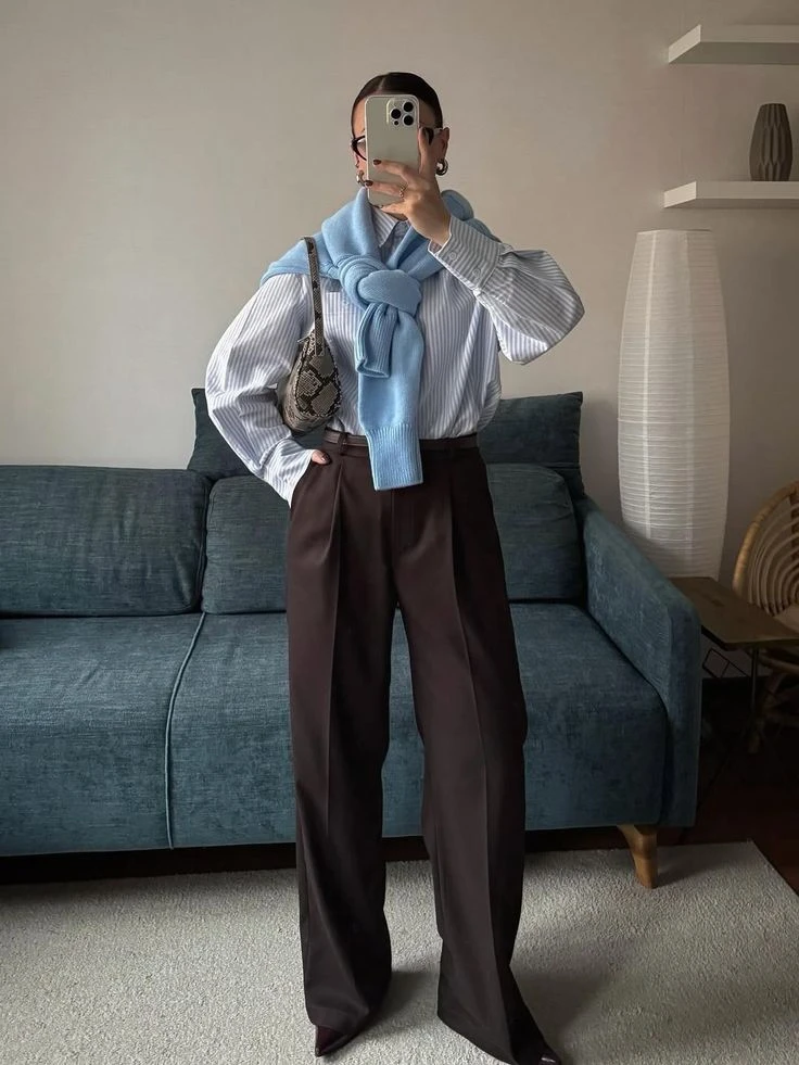 Una de las fórmulas más elegantes para incorporar los colores argentinos es combinar un suéter celeste con una camisa blanca por debajo y un pantalón sastrero oscuro.