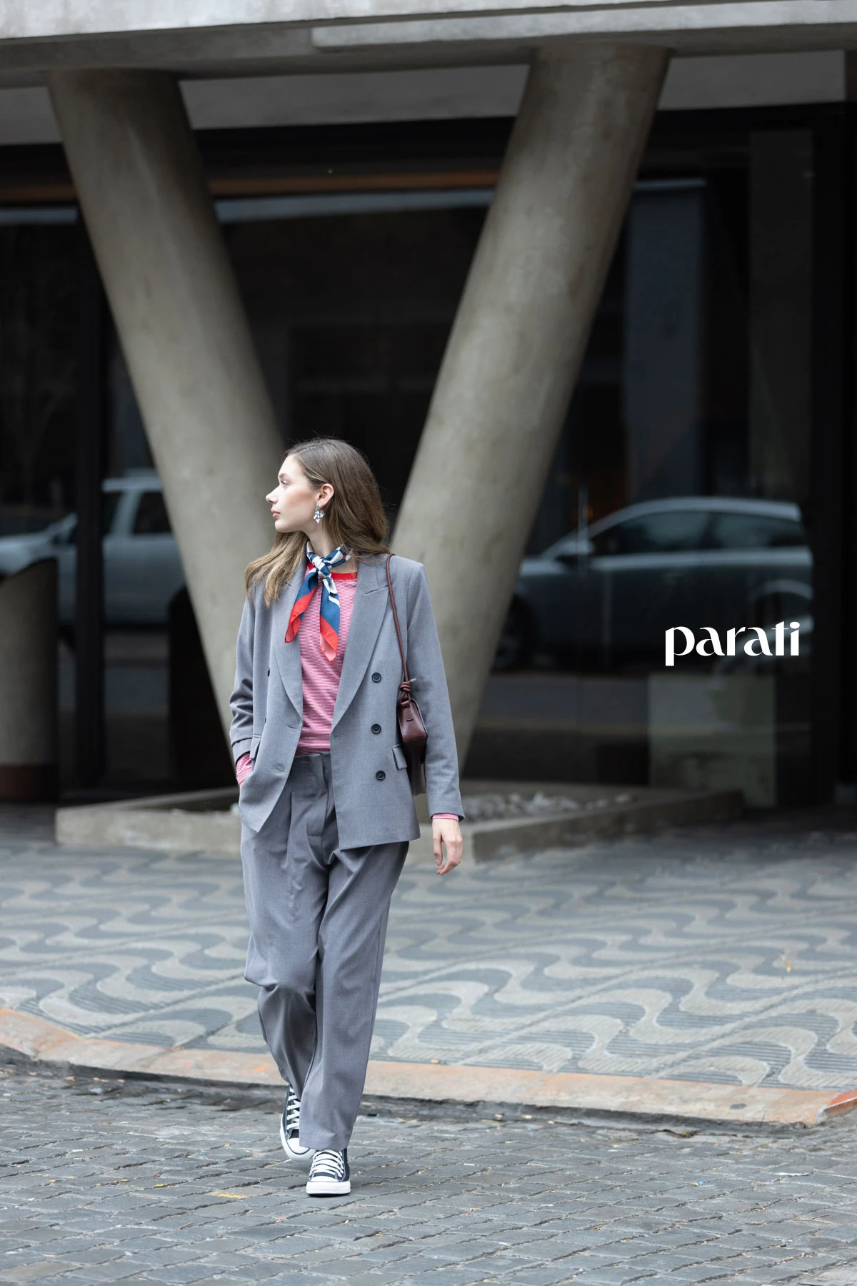 Traje de blazer cruzado y pantalón gris @claraibargurenoficial, remera manga larga rayada @boliviauniverso, zapatillas de lona negra @converse_ar, pañuelo combinado @perramusoficial, cartera de cuero bordó @mishkabuenosaires y aros flor plateados @ritace.accesorios