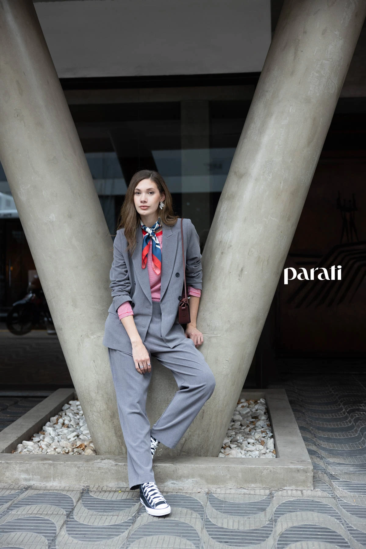 Traje de blazer cruzado y pantalón gris @claraibargurenoficial, remera manga larga rayada @boliviauniverso, zapatillas de lona negra @converse_ar, pañuelo combinado @perramusoficial, cartera de cuero bordó @mishkabuenosaires y aros flor plateados @ritace.accesorios