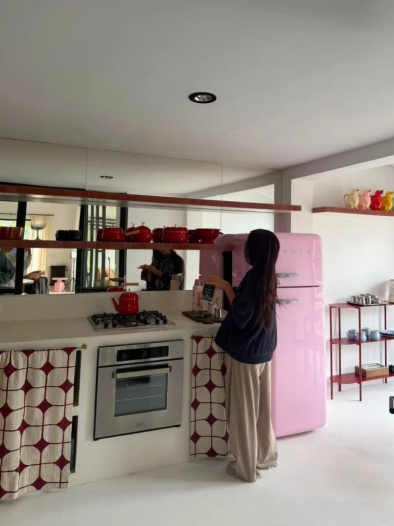 Uno de los ambientes más llamativos es la cocina, dominada por una heladera retro color rosa pastel que se convirtió en el gran foco visual del espacio.