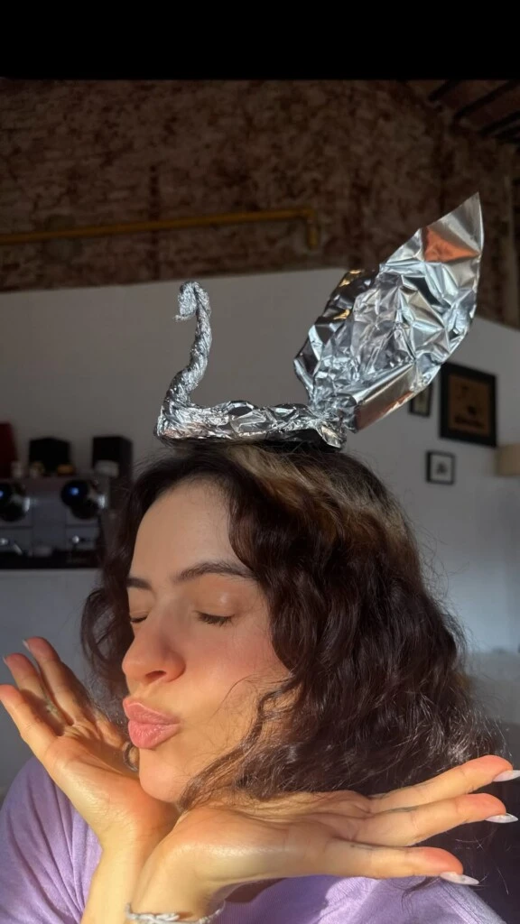 En una de las imágenes apareció posando con un cisne de papel realizado con uno de los envoltorios de la mesa, que terminó usando como un original tocado sobre su cabeza mientras posaba a cámara.